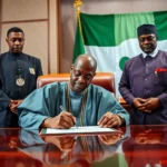 President bola ahmed tinubu signing the electoral act 2026 document at the state house.