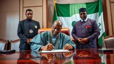 President bola ahmed tinubu signing the electoral act 2026 document at the state house.